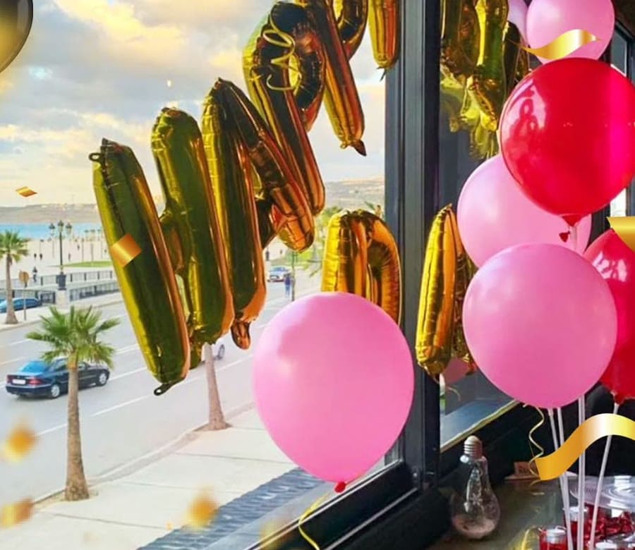 Ballons dorés et roses devant la baie vitrée qui donne sur la Corniche