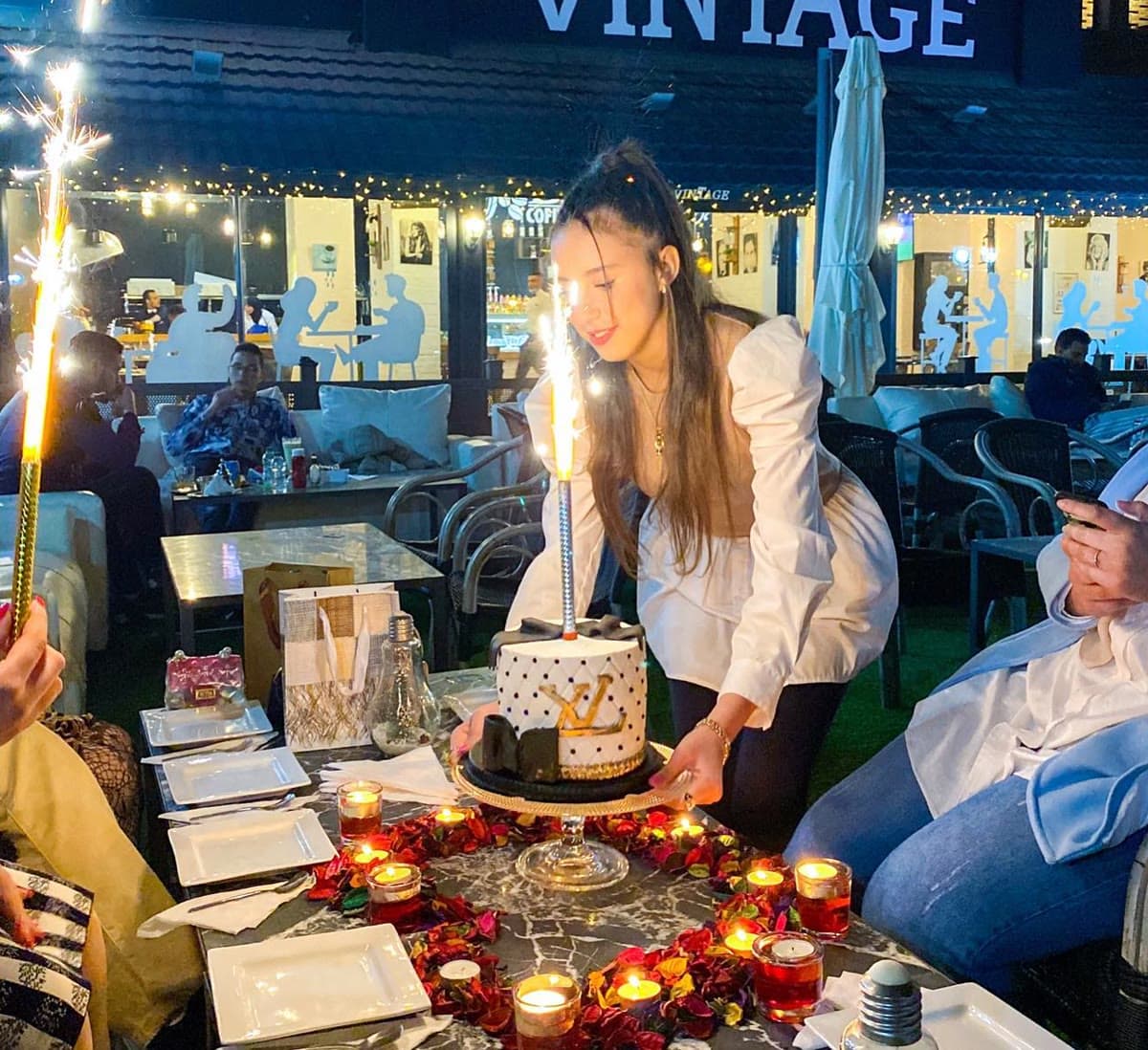 Un gâteau d’anniversaire aux bougies sur une table de la terrasse, le soir