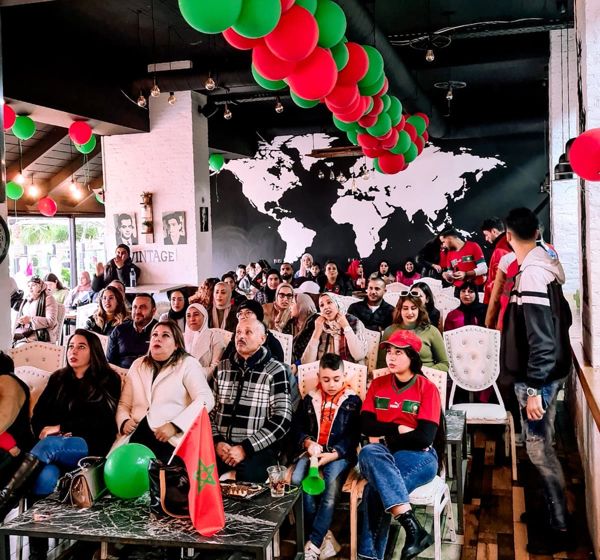 Supporters devant l’écran géant dans la salle décorée aux couleurs du Maroc