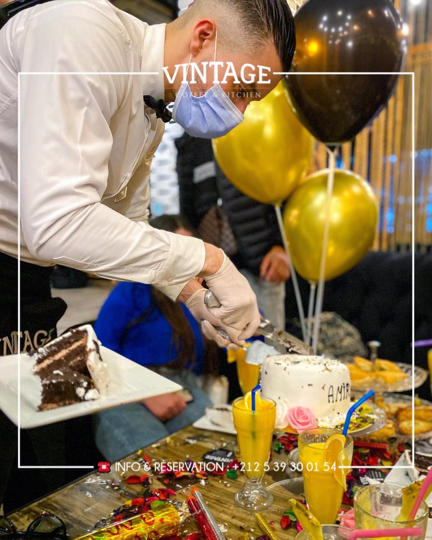 Service du gâteau d’anniversaire entouré de ballons dorés